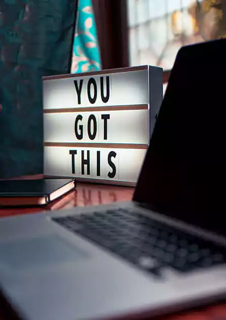 Laptop and a 'You Got This' sign symbolizing successful projects at a web development company.